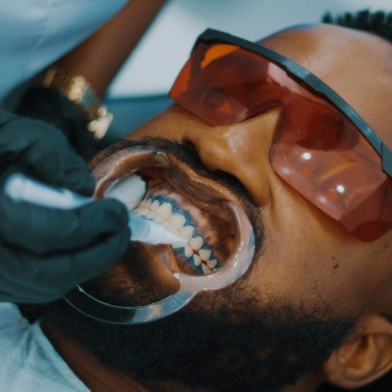 a man getting his teeth brushed by a dentist